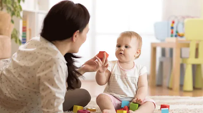 Happy babysitter holds child